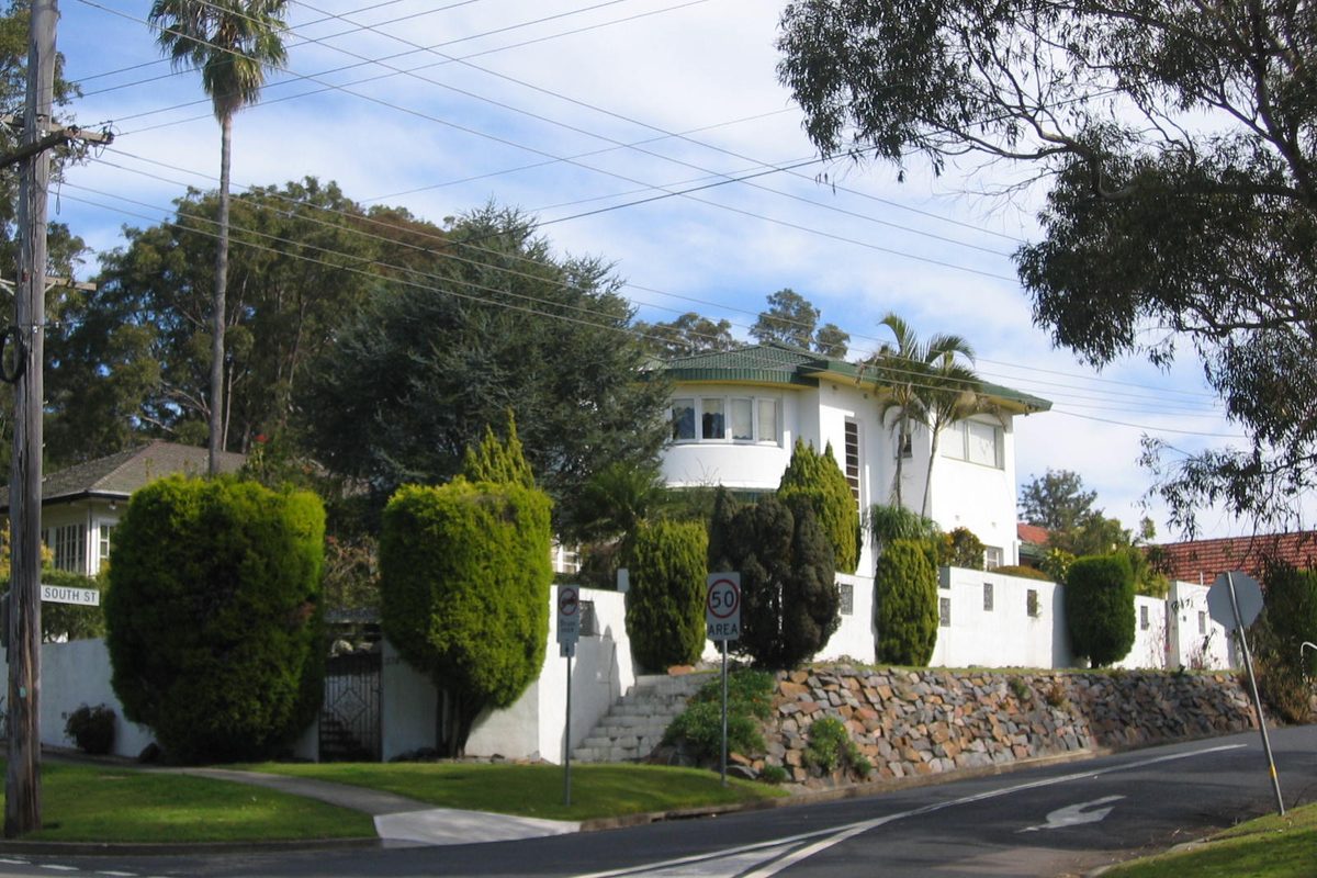 A white two-storey house on a corner in Adamstown Heights